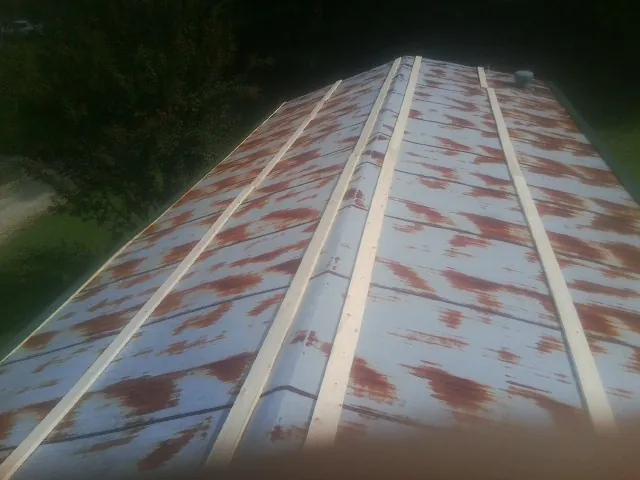 Rusted metal roof panels with new wood purlins before replacement — Storm Damage Roof Repair in Delco by Roofing Brothers