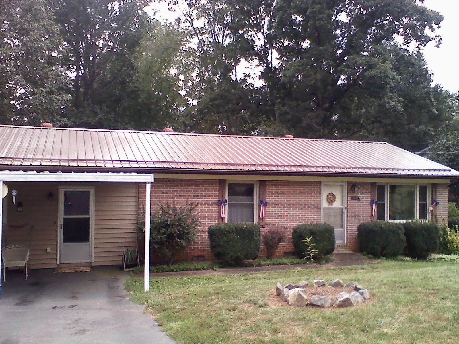 Bronze metal roof and carport on a brick ranch home — Roof Repair work by our crew in Delco